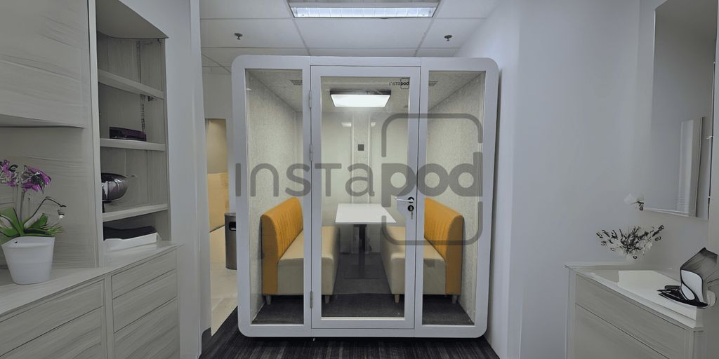 A modern soundproof pod with seating in a minimalistic space.
