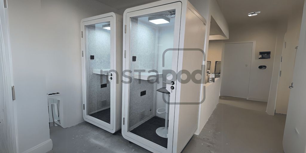 Two modern phone booths in a minimalist interior space.