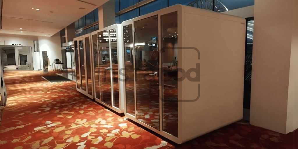 Modern glass-walled booths in a spacious interior setting.