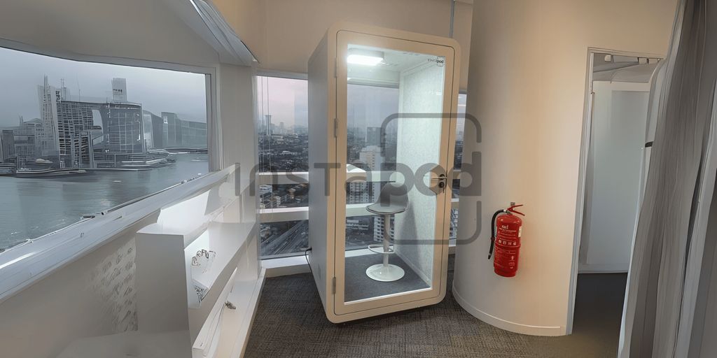 Modern workspace with glass booth, city view, and fire extinguisher.