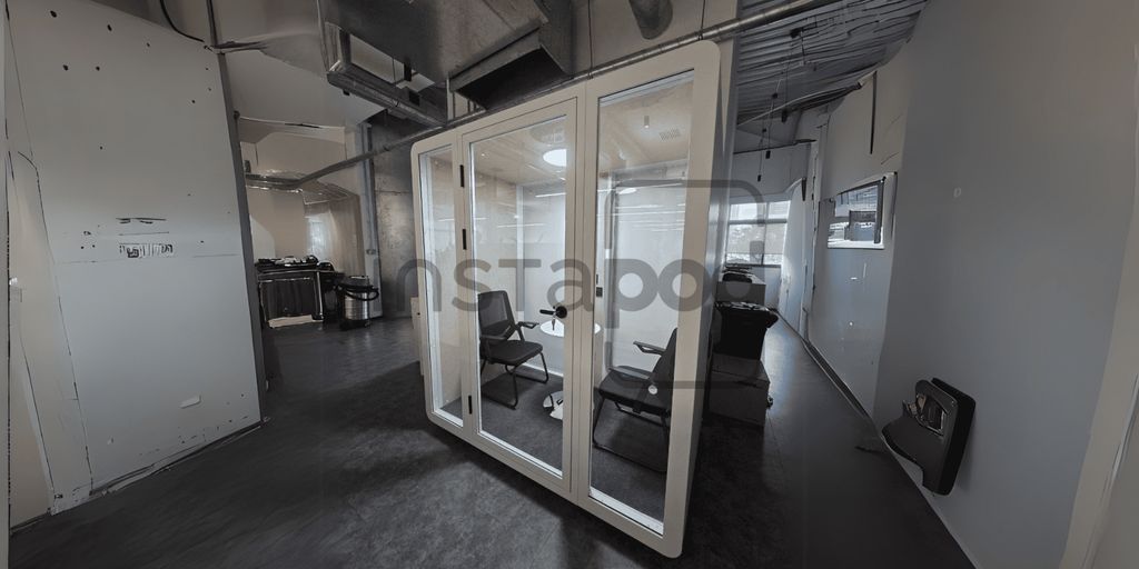 Modern office space with glass meeting room and chairs.