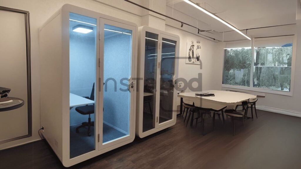 Modern office space featuring soundproof booths and meeting area.