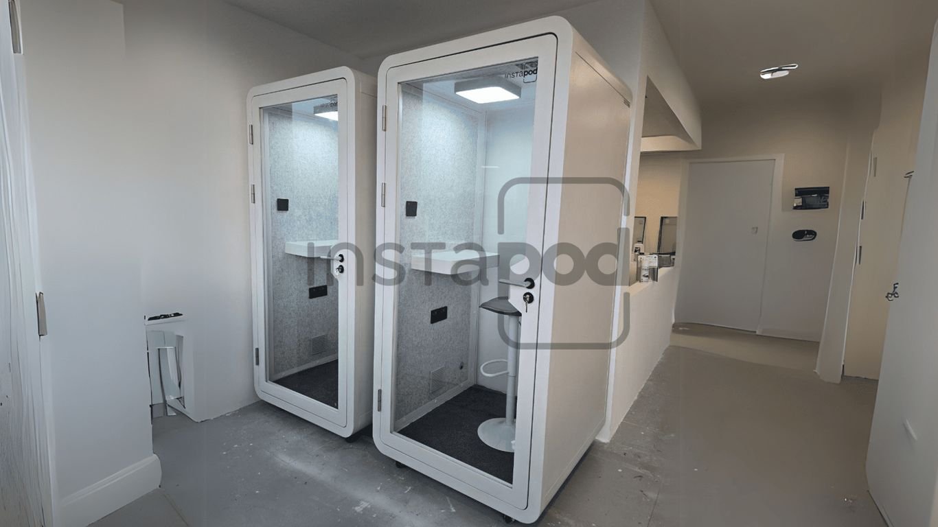 Two modern phone booths in a minimalist interior space.