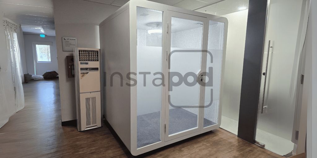 A modern, clear pod in a hallway setting.