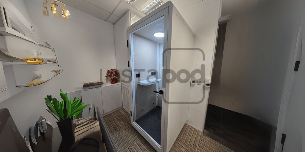 Modern office space featuring a glass-walled meeting pod.