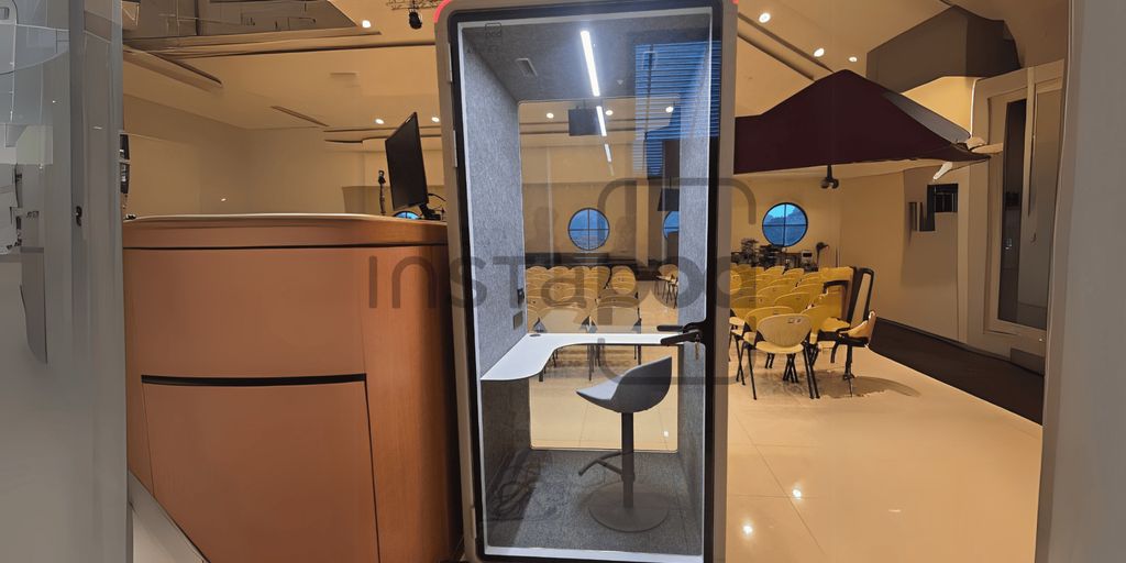 Modern workspace with a soundproof booth and seating area.