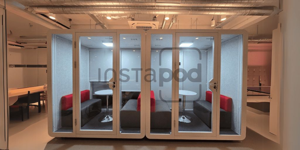 Modern workspace pod with seating and tables for collaboration.