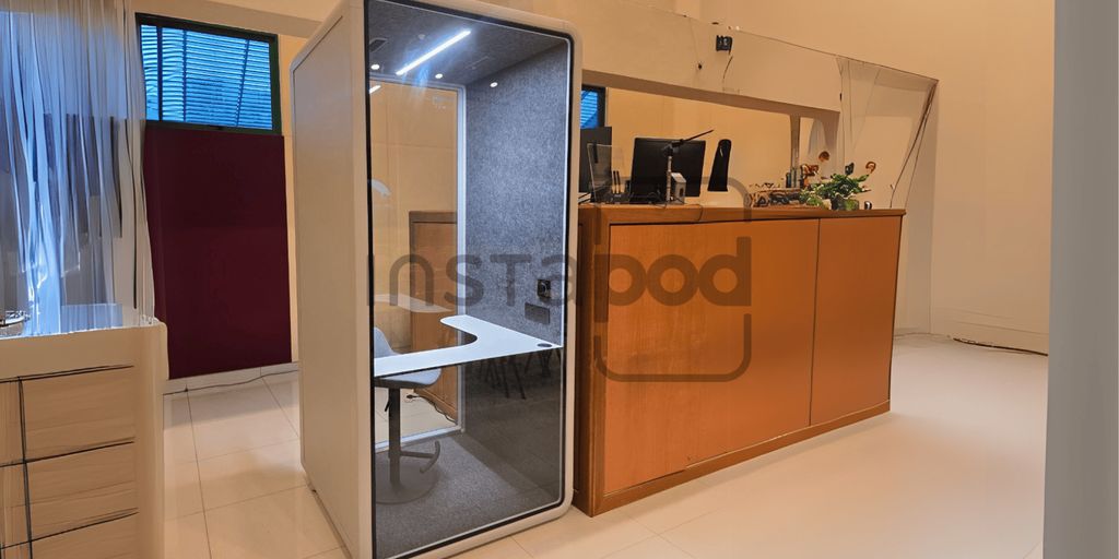 Modern workspace featuring a privacy pod and reception area.