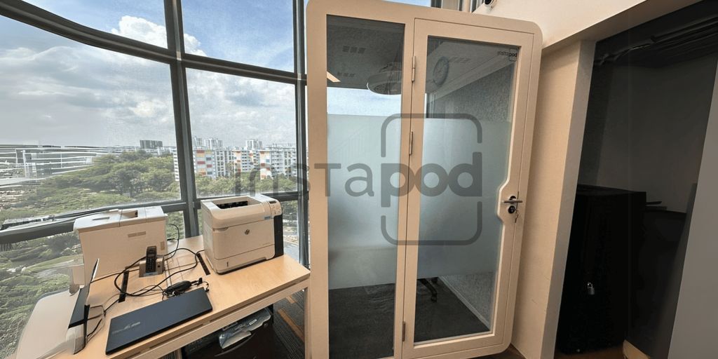 A modern office space featuring a soundproof booth and equipment.