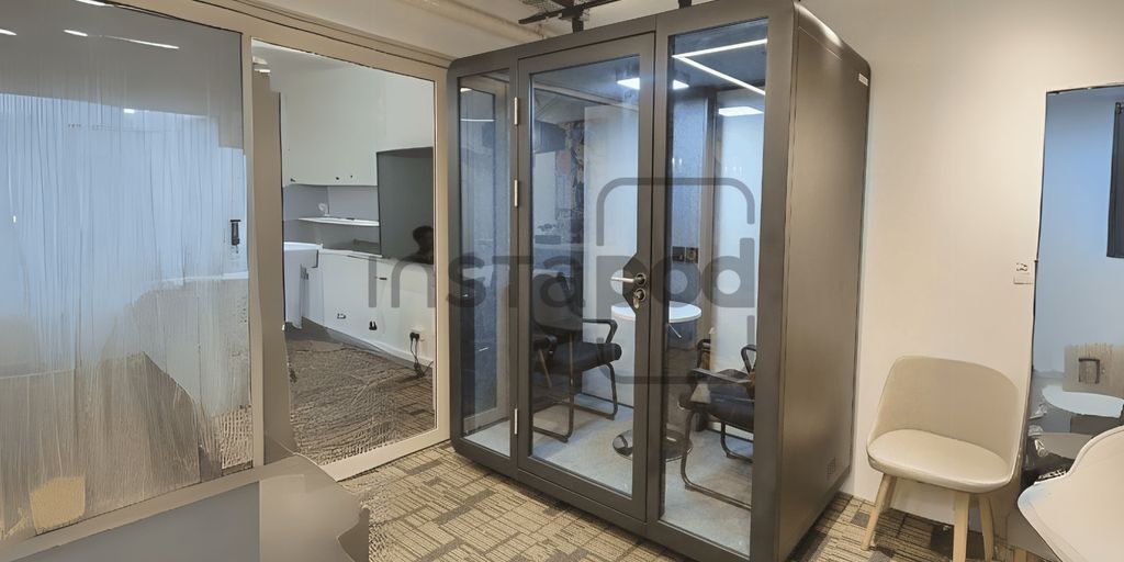Modern office space featuring a glass meeting pod.