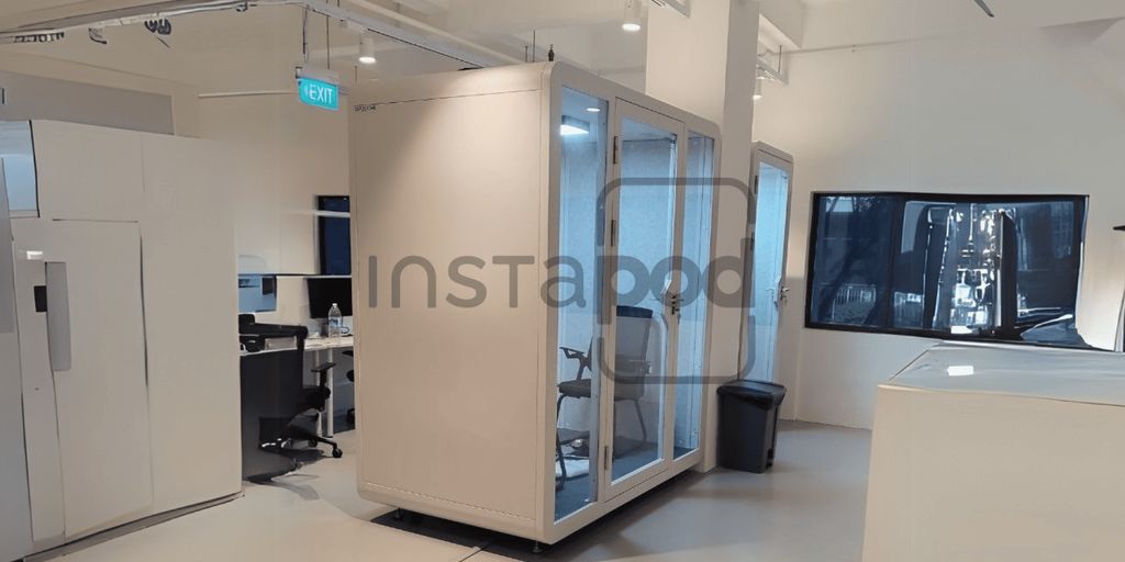Modern office space featuring a glass-enclosed meeting pod.