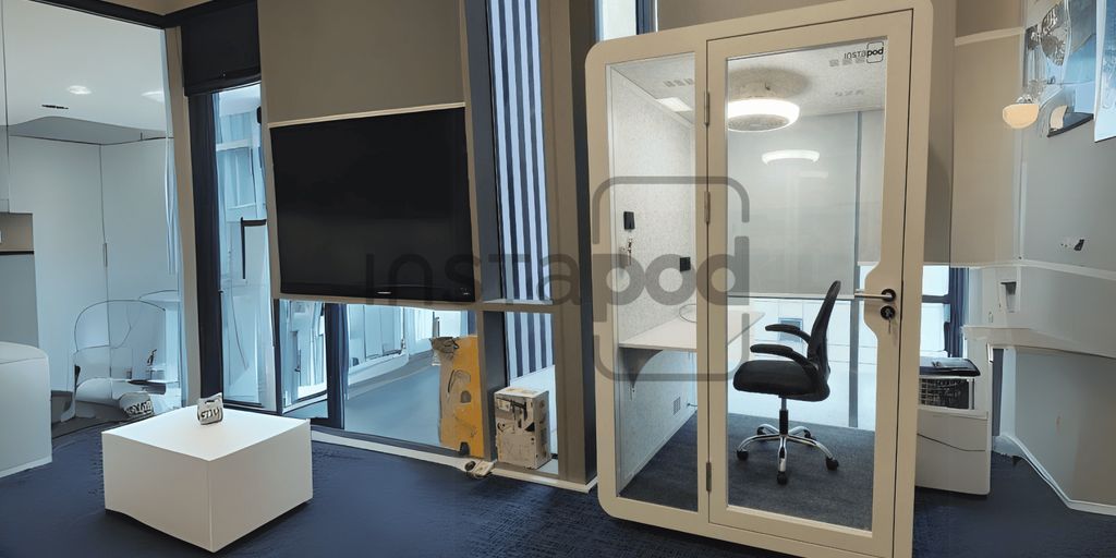 Modern office interior featuring soundproof booth and minimalist design.
