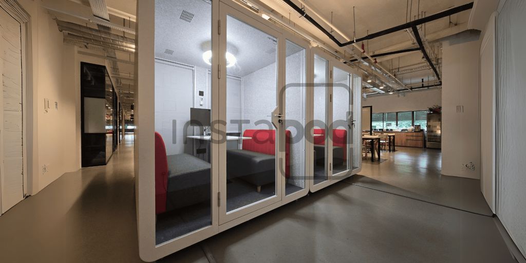 Modern office space featuring meeting pods and comfortable seating.
