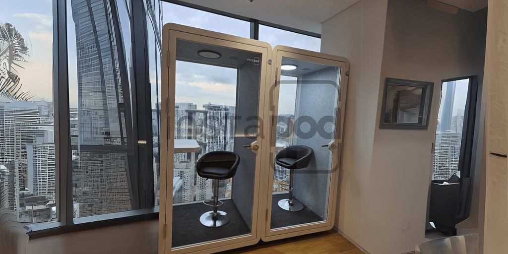 Two soundproof pods with chairs in a modern office space.