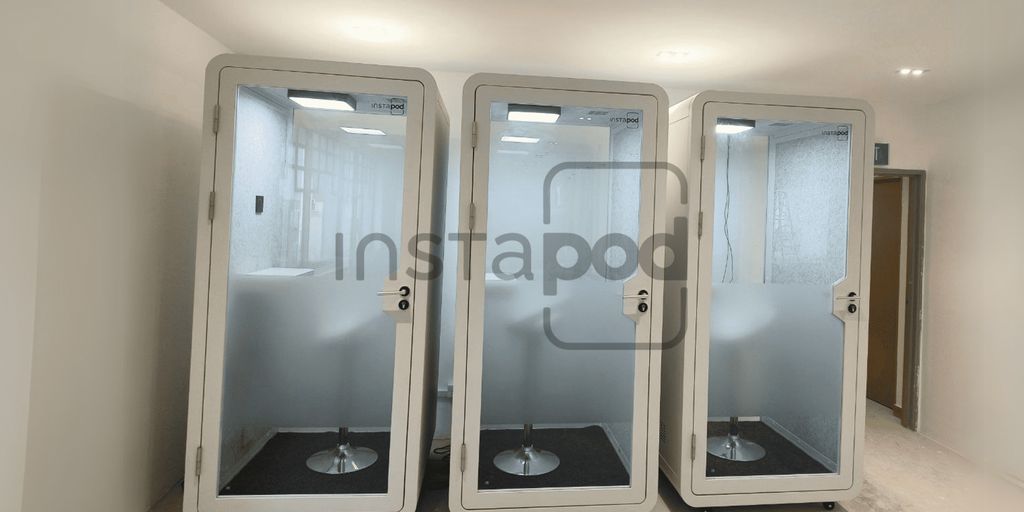 Three modern soundproof pods in a spacious interior setting.