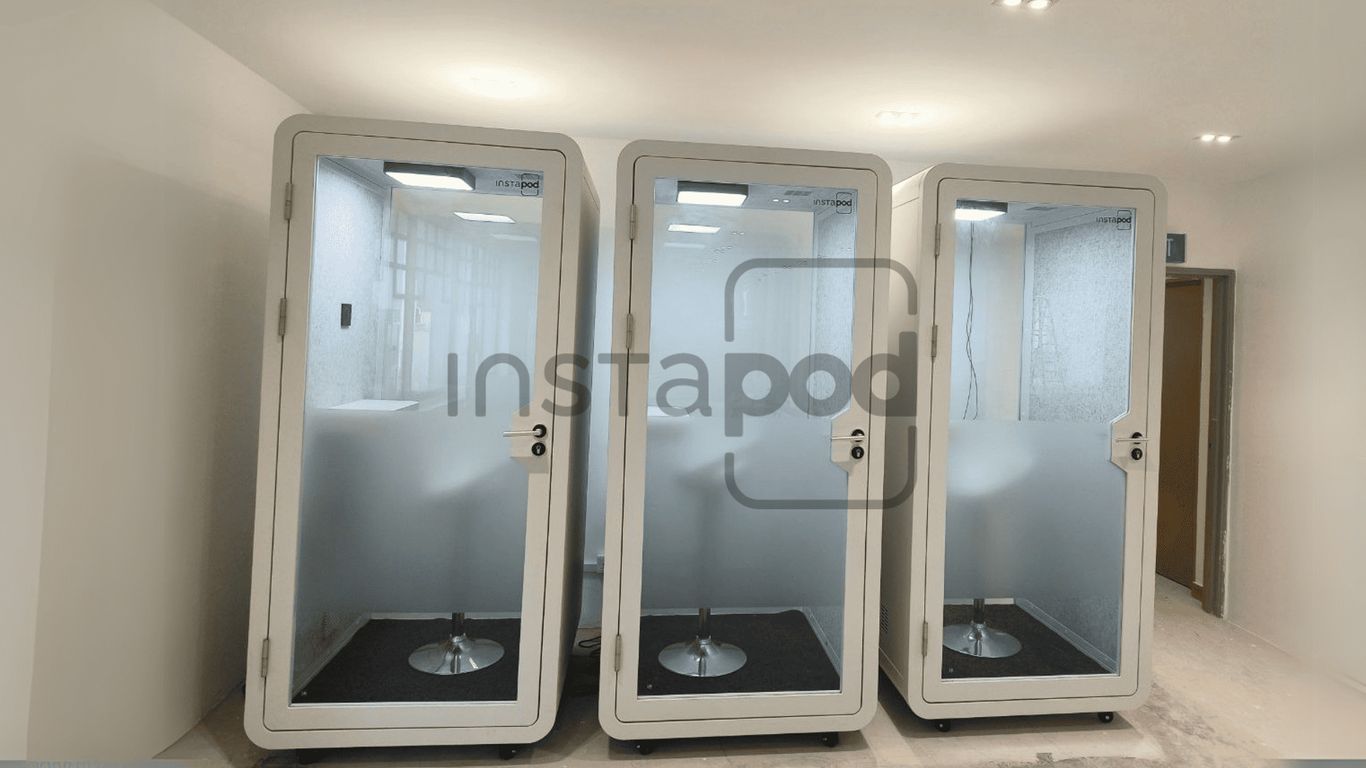 Three modern soundproof pods in a spacious interior setting.