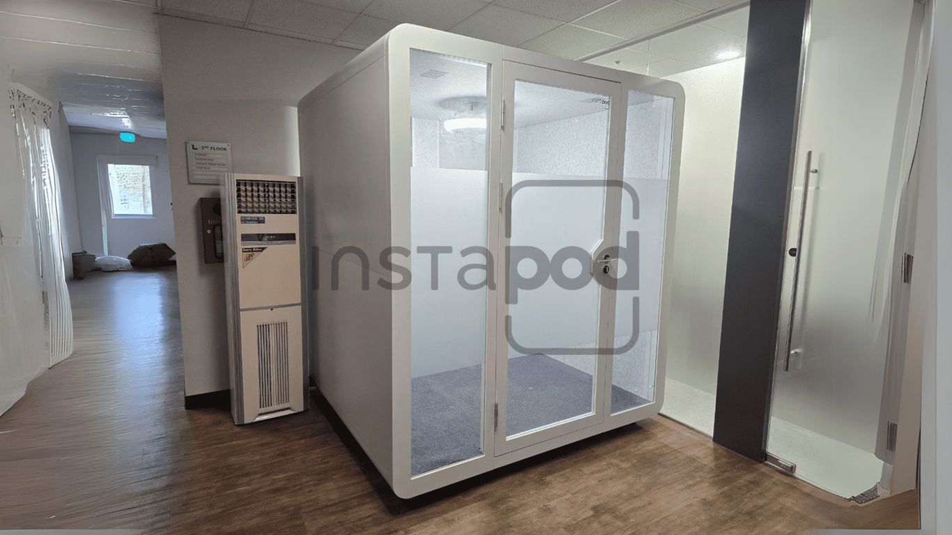 A modern, clear pod in a hallway setting.