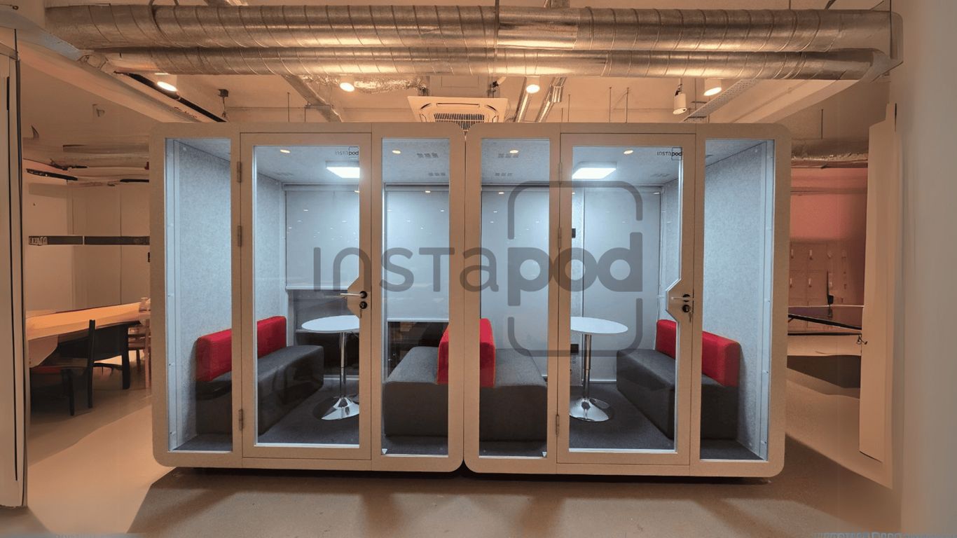Modern workspace pod with seating and tables for collaboration.