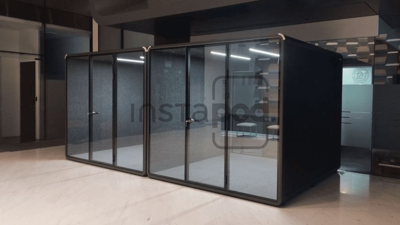 Modern glass-walled office pods in a minimalist workspace.