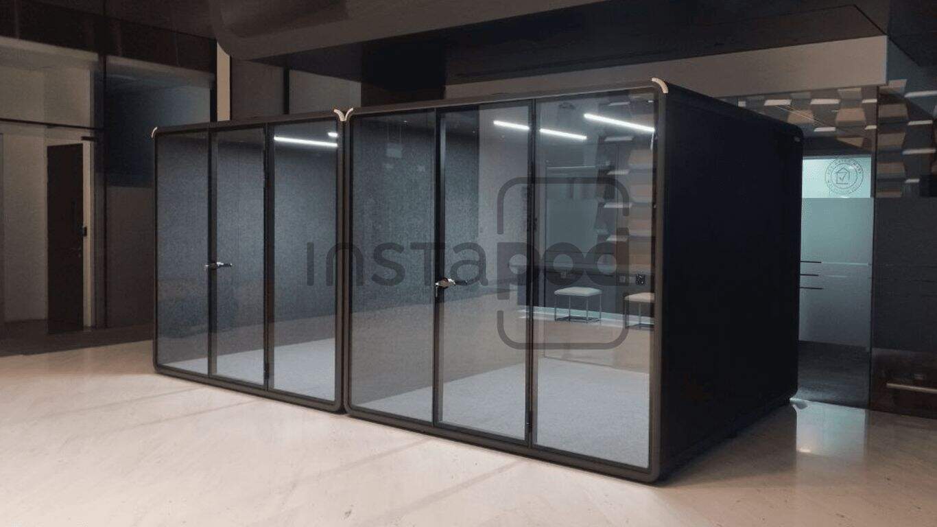 Modern glass-walled office pods in a minimalist workspace.