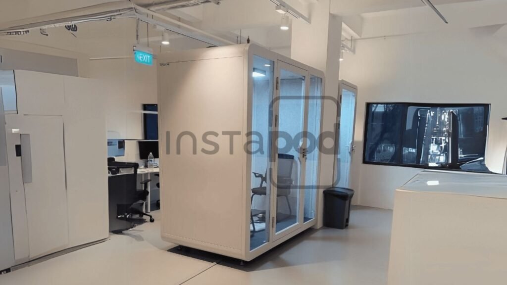 Modern office space featuring a glass-enclosed meeting pod.