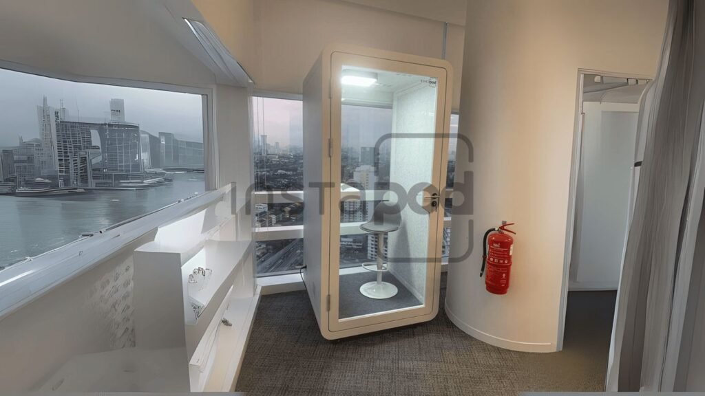 Modern workspace with glass booth, city view, and fire extinguisher.
