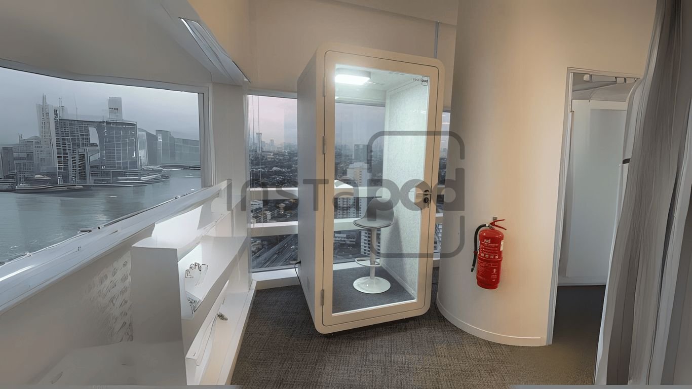 Modern workspace with glass booth, city view, and fire extinguisher.