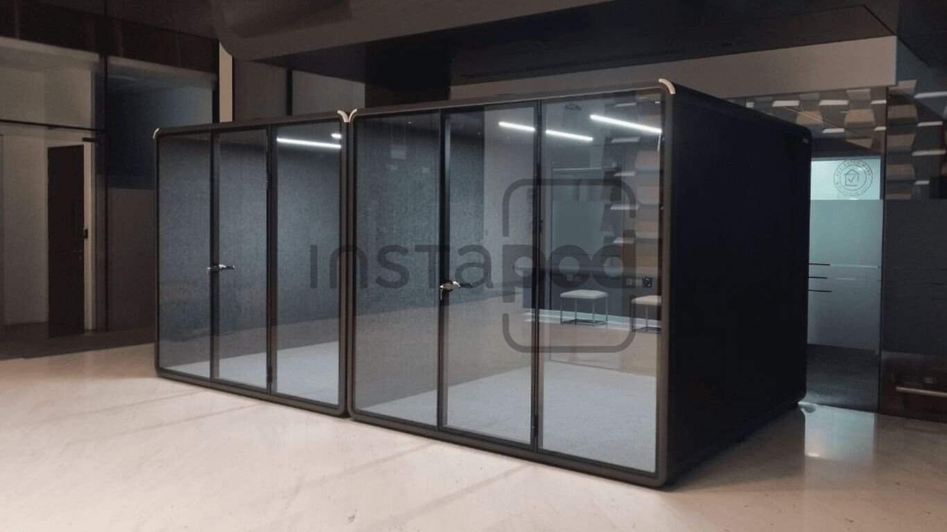 Modern glass-walled office pods in a minimalist workspace.