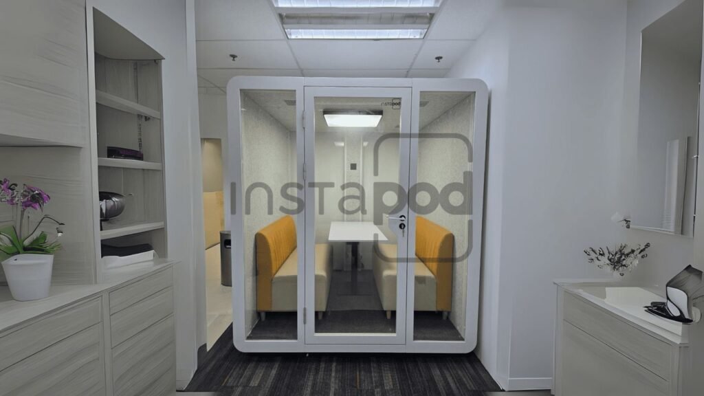 A modern soundproof pod with seating in a minimalistic space.