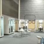 Modern, glass-walled meeting pods in a spacious area.