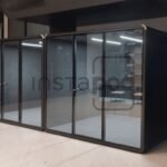 Modern glass-walled office pods in a minimalist workspace.