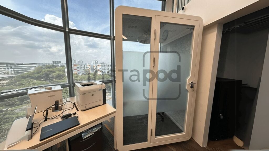 A modern office space featuring a soundproof booth and equipment.