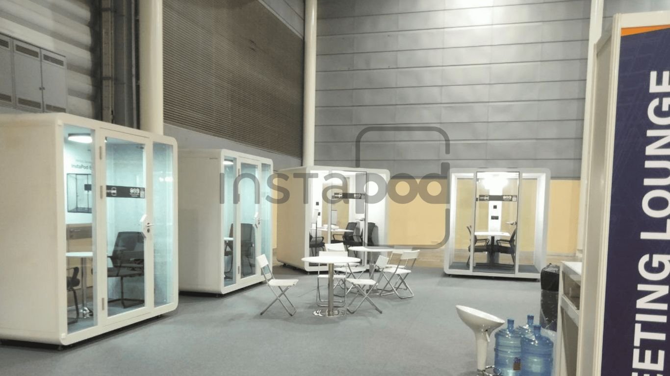 Modern, glass-walled meeting pods in a spacious area.