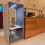 Modern workspace featuring a privacy pod and reception area.