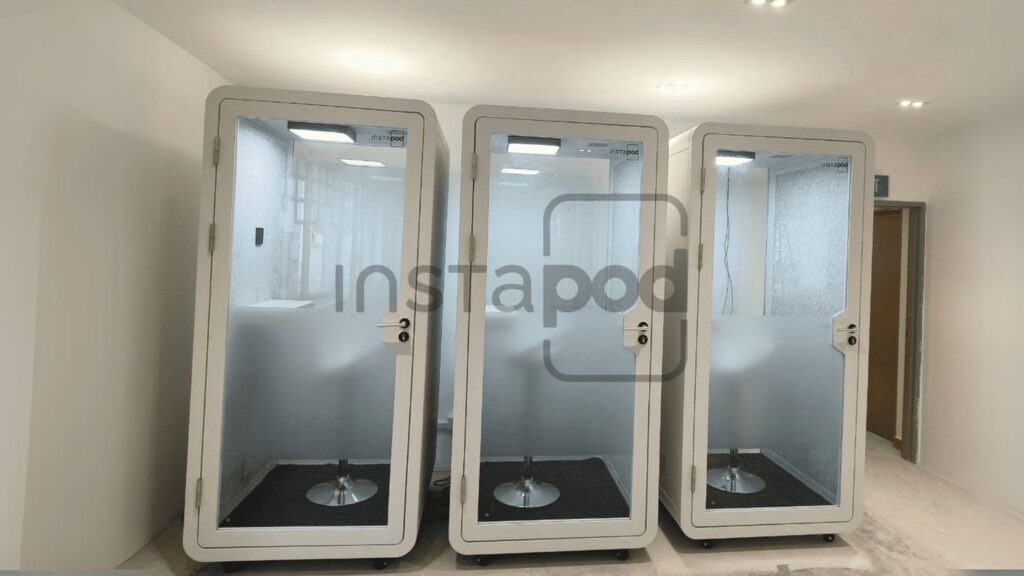 Three modern soundproof pods in a spacious interior setting.