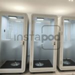 Three modern soundproof pods in a spacious interior setting.