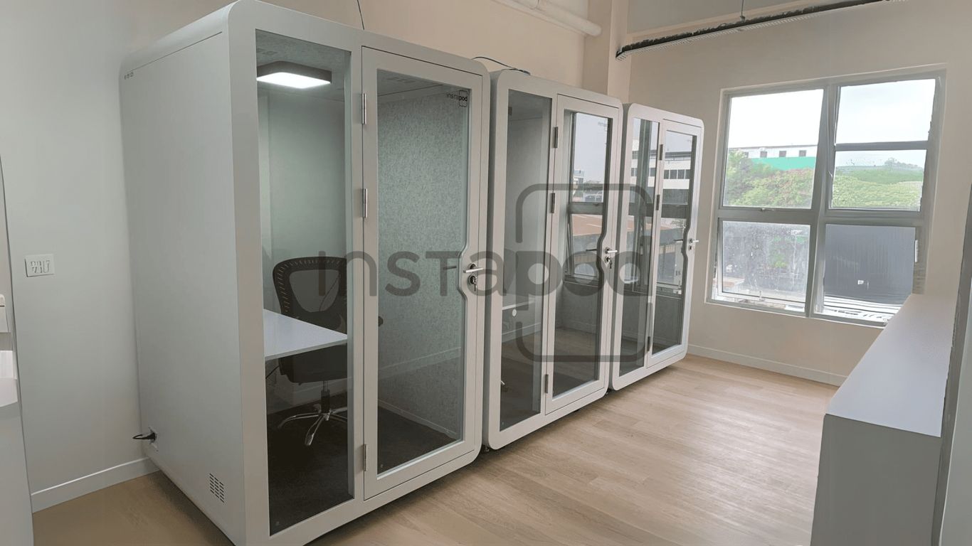 An office space featuring multiple soundproof cubicles and a window.