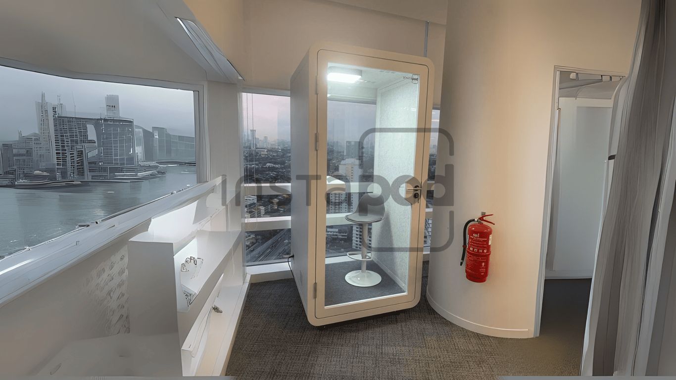 Modern workspace with glass booth, city view, and fire extinguisher.