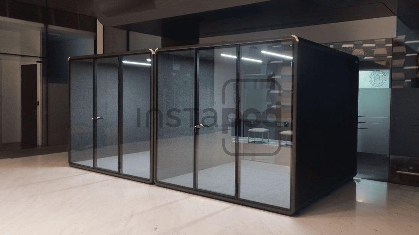 Modern glass-walled office pods in a minimalist workspace.