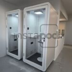 Two modern phone booths in a minimalist interior space.