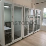 An office space featuring multiple soundproof cubicles and a window.