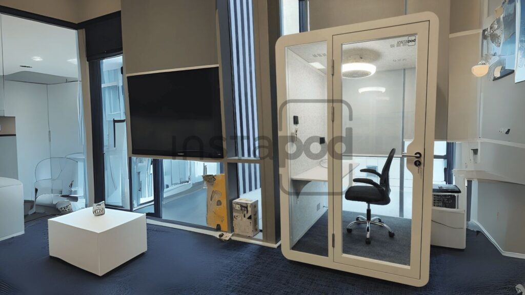 Modern office interior featuring soundproof booth and minimalist design.