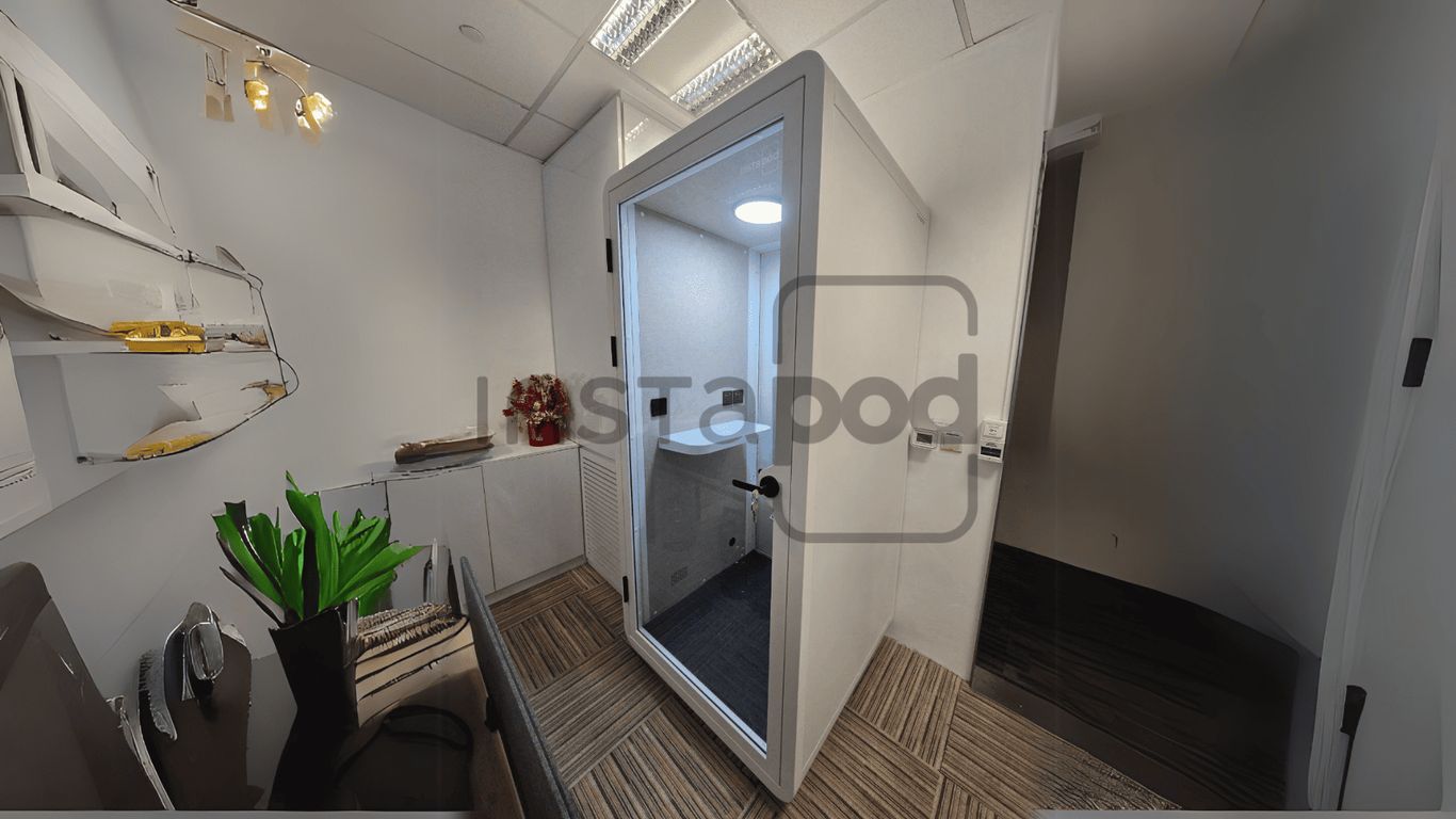 Modern office space featuring a glass-walled meeting pod.