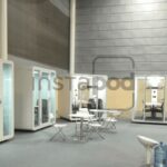 Modern, glass-walled meeting pods in a spacious area.