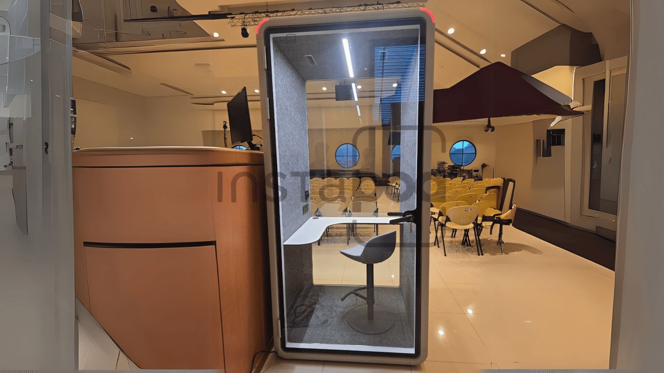 Modern workspace with a soundproof booth and seating area.