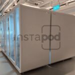 Modern office space featuring modular white work pods.