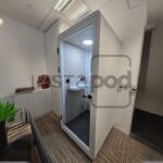 Modern office space featuring a glass-walled meeting pod.