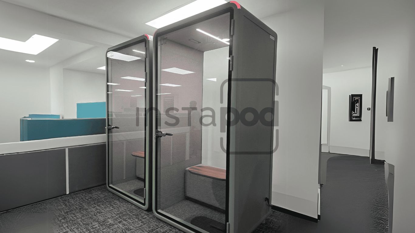 Two modern soundproof booths in a contemporary office setting.